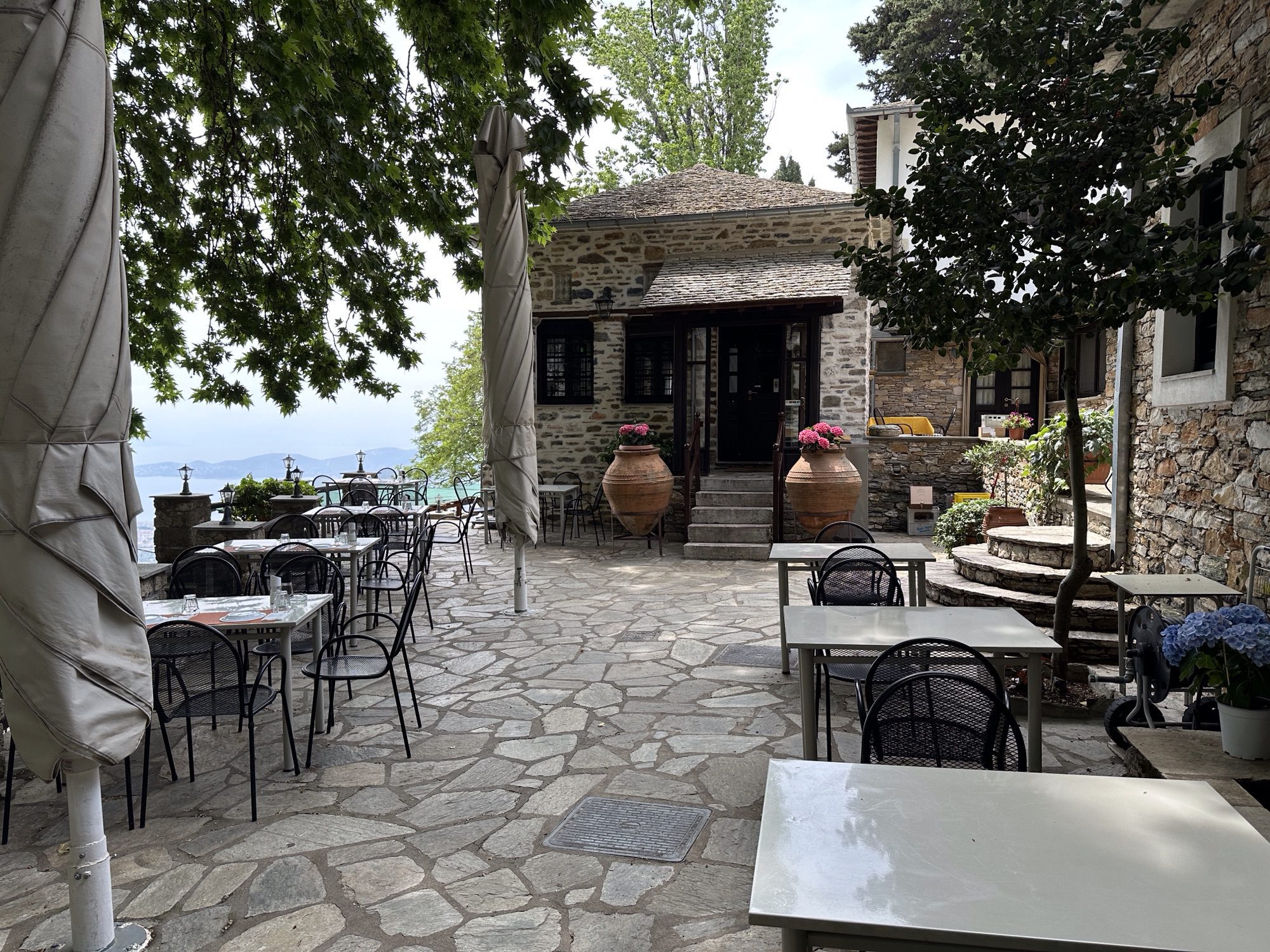 Café-terras met tafeltjes en oud gebouw in Makrinitsa