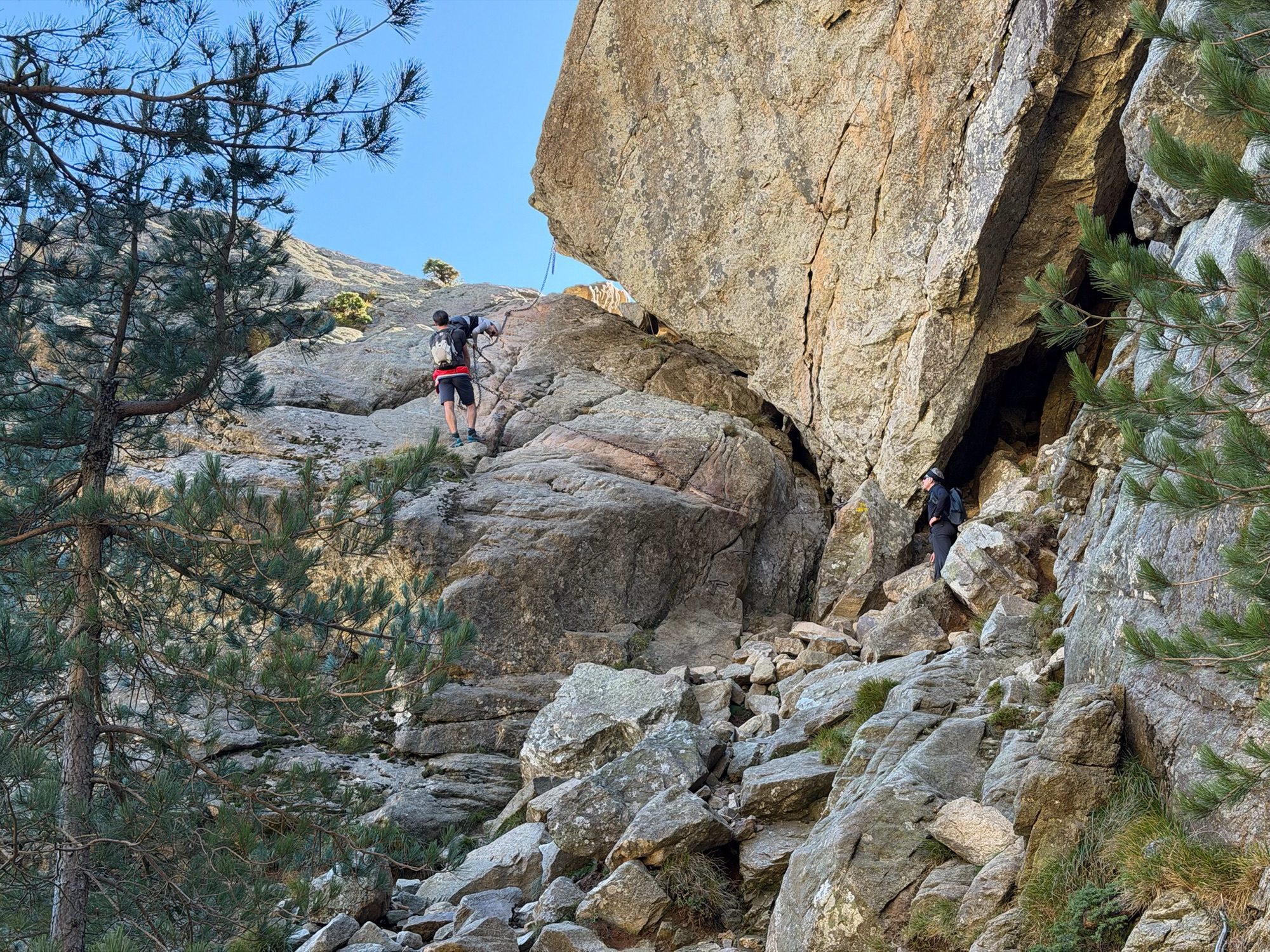 Toeristen klauteren over rotsen omhoog.