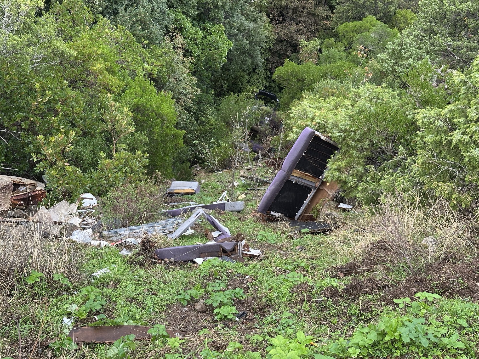 Ravijn met brokstukken van auto.