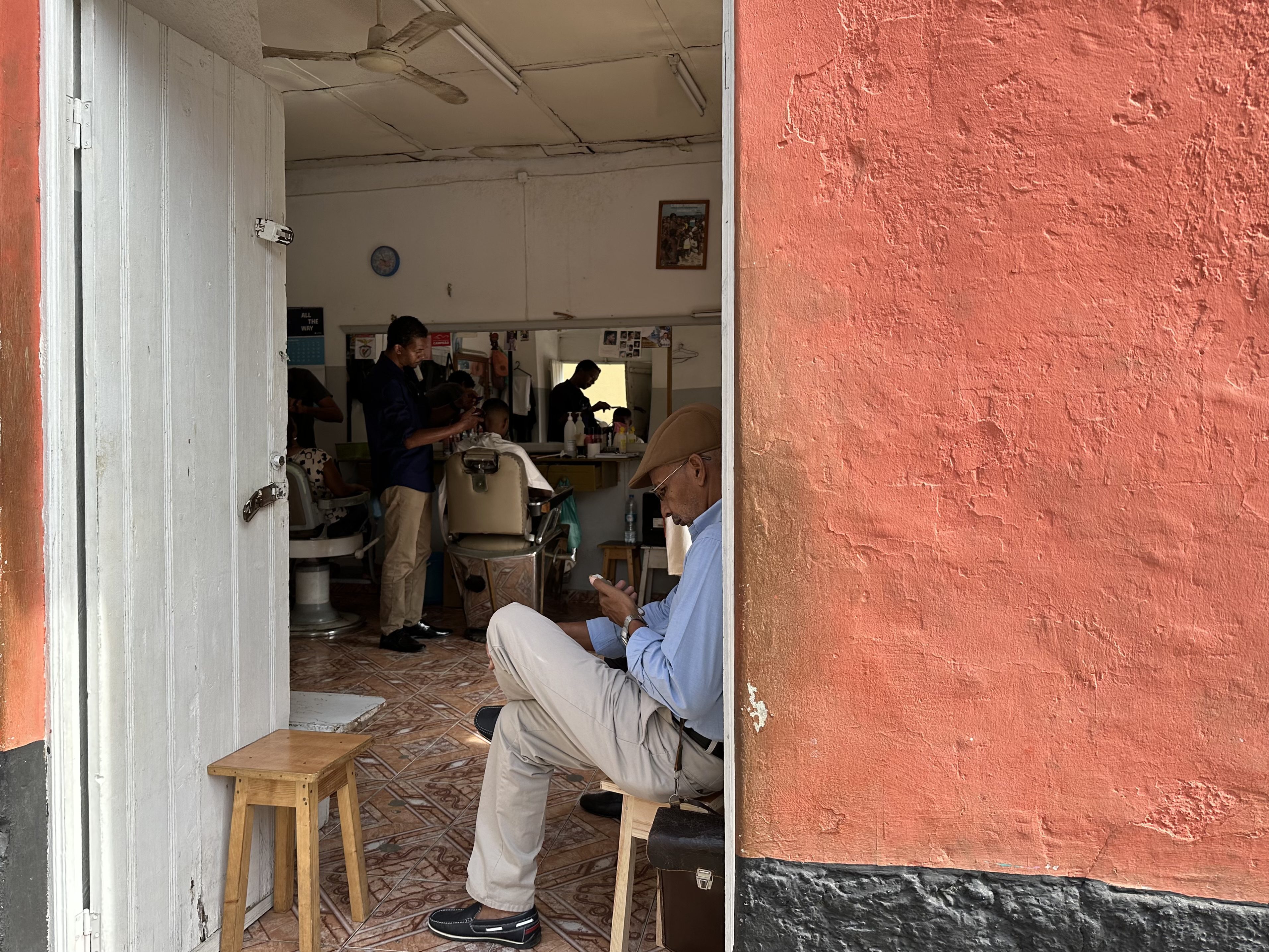 Kapperssalon met rechts een oker-rode muur in Praia.